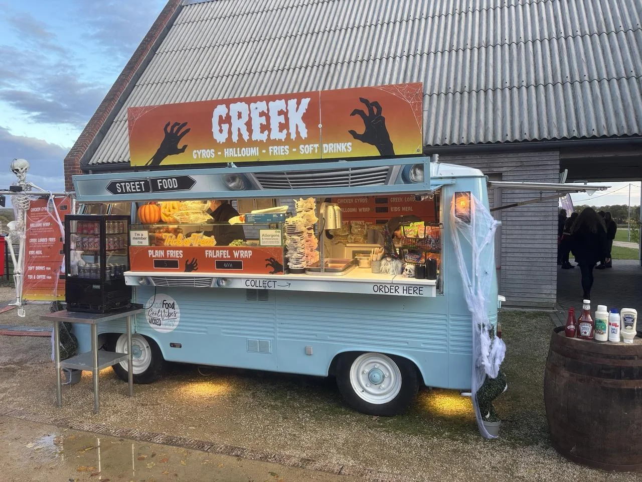 Vintage Greek van decorated with skeletons, pumpkins and cobwebs at Wimpole in daylight